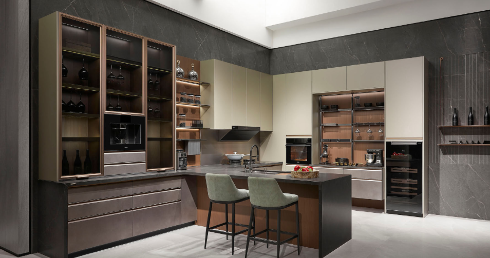 Cocina con vitrinas de marco bronce, iluminación interior y península de piedra oscura